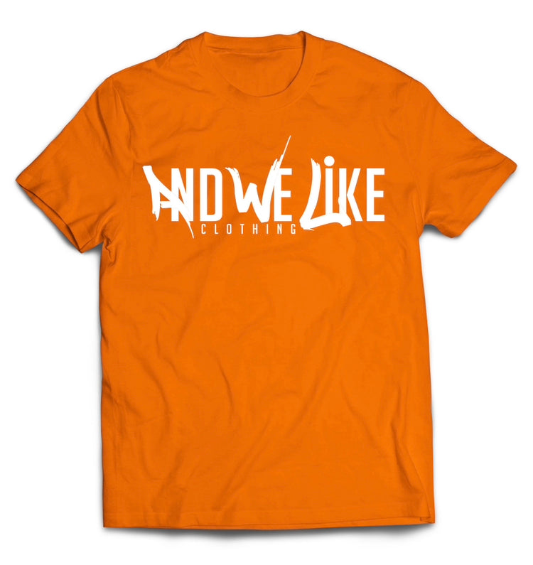 A orange T-shirt with the text "AND WE LIKE CLOTHING" printed in white on the front. The letters "AND WE LIKE" are creatively designed while "CLOTHING" is in a straightforward font below.