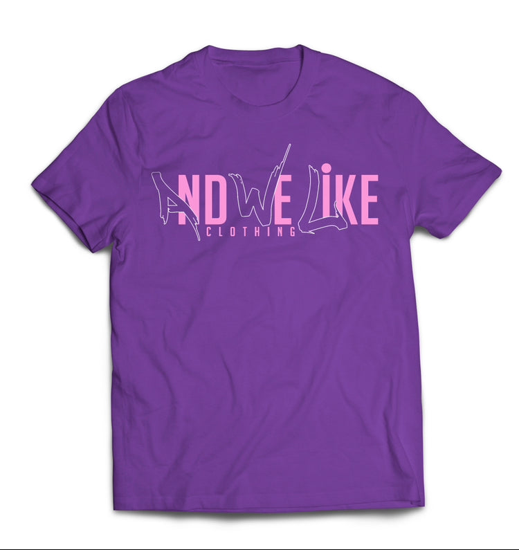 A purple T-shirt with the text "AND WE LIKE CLOTHING" printed in pink on the front. The letters "AND WE LIKE" are creatively designed while "CLOTHING" is in a straightforward font below.