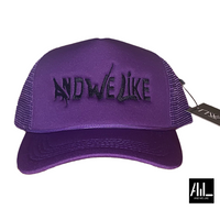 Front facing purple and black  And We Like trucker hat is a classic blend of style and function. The adjustable snapback closure ensures it suits all head sizes. Ideal for a casual, sporty look with its timeless design.